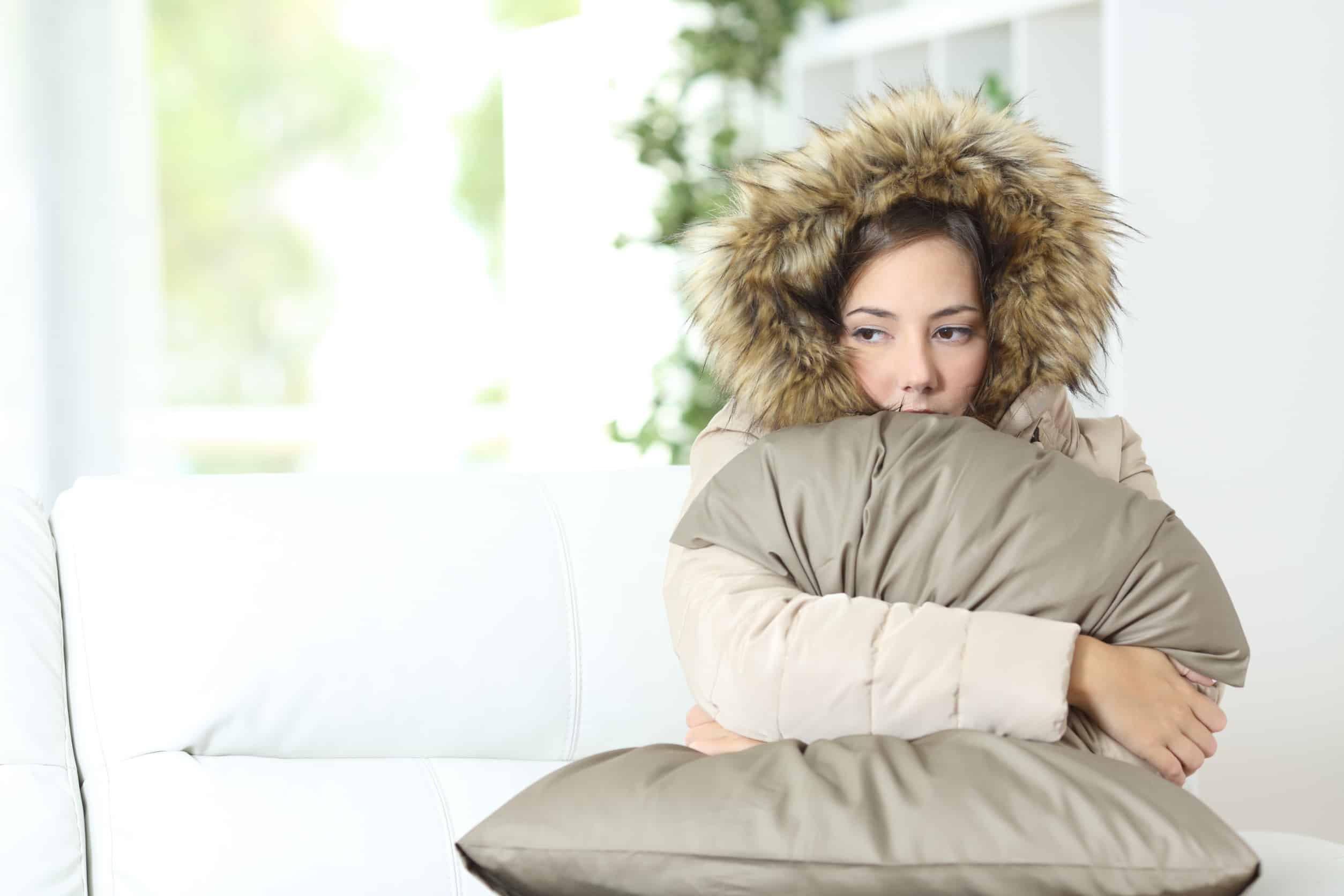 cold woman wearing jacket inside house because heater is broken